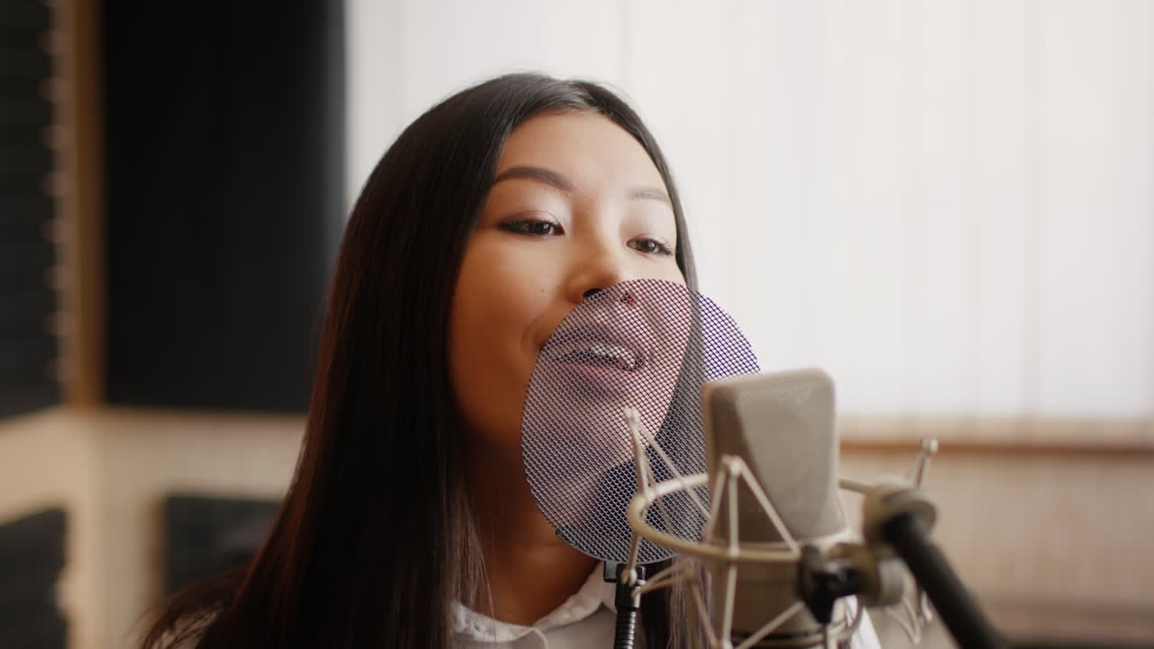 녹음 스튜디오 에서 마이크 로 노래 하는 여자