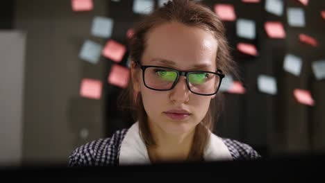 Mujer-Joven-Con-Anteojos-Trabajando-En-Una-Laptop-En-La-Oficina