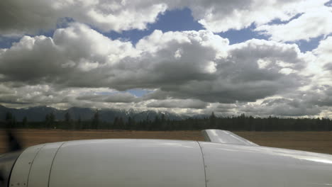 wing of small plane travelling along the runway of an airport taking off into the air