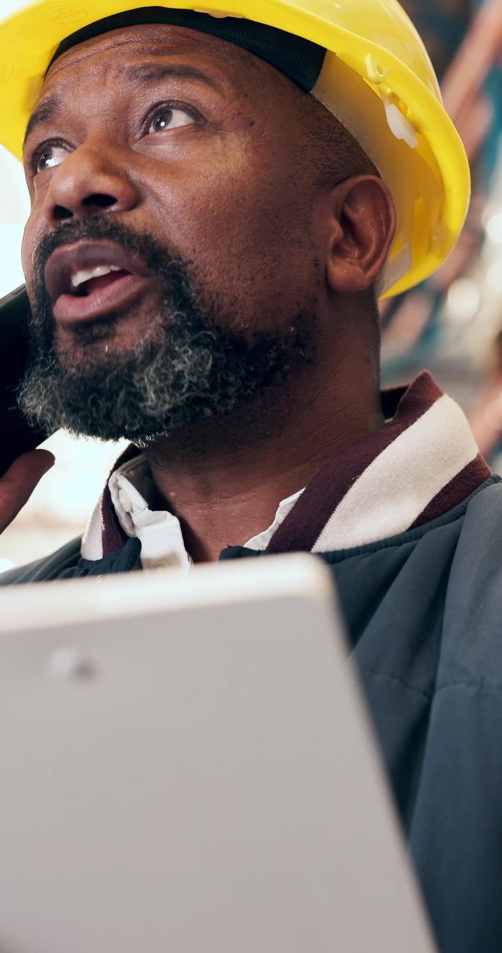 Warehouse Manager Talking on Phone While Holding Clipboard