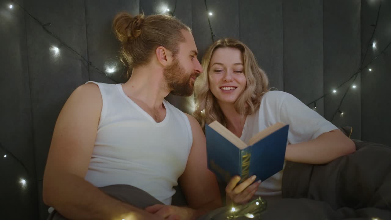 Coppia che legge un libro a letto
