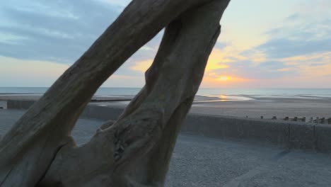 Pan-revealing-driftwood-during-sunset-in-slow-motion-at-Fleetwood,-Lancashire,-UK