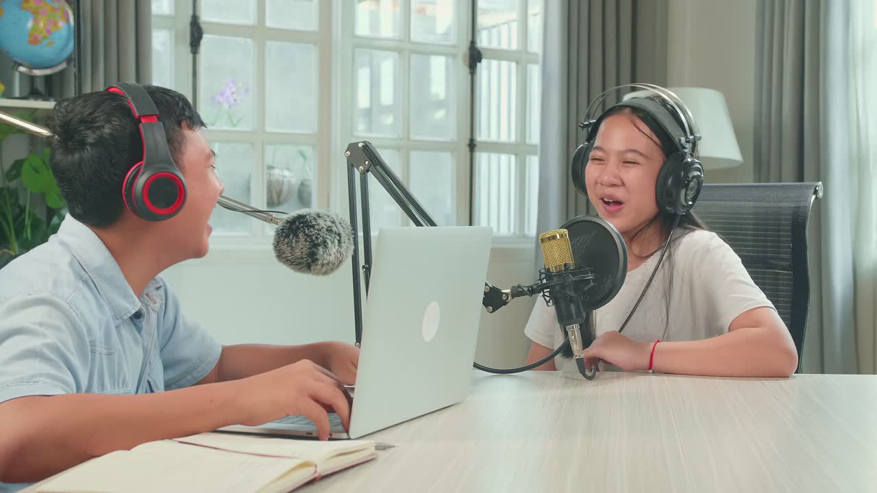 Happy Asian Boy Host Record Podcast Use Microphone Wear Headphone With Laptop Interview Guest Conversation For Content In His Home Studio. Content Creator Concept