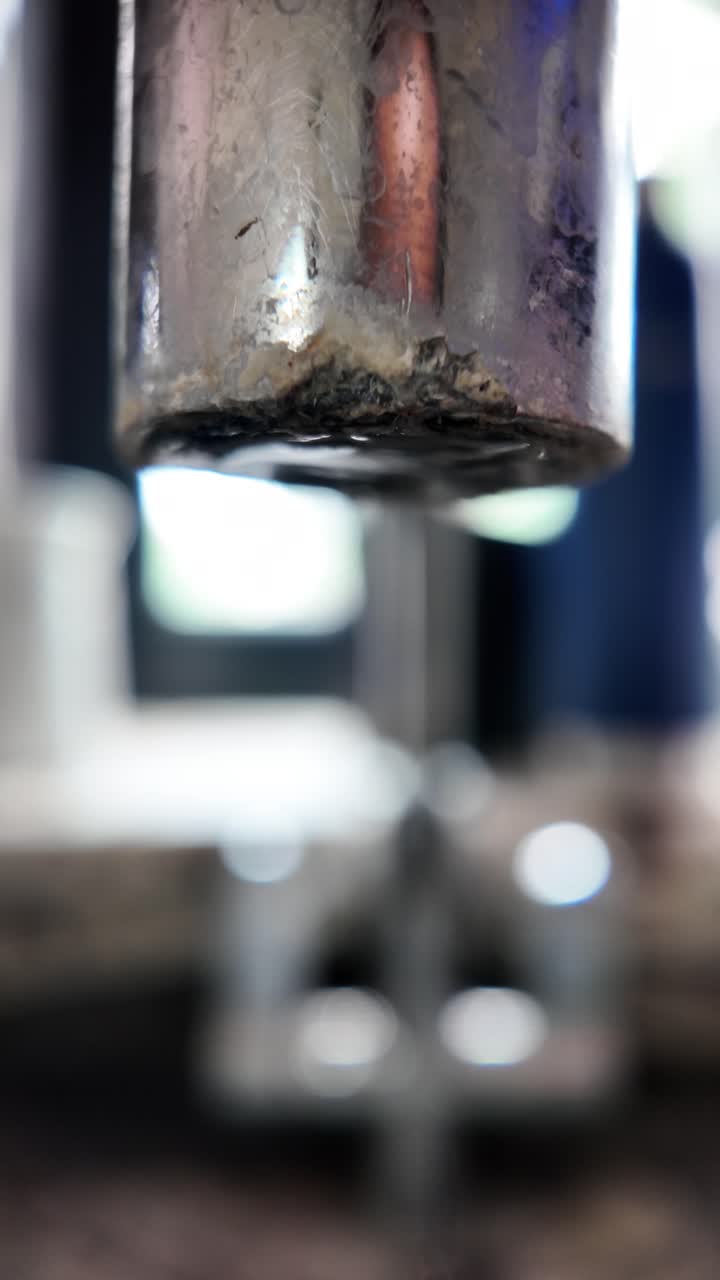 Slow motion water droplet falling from faucet, capturing focus and motion