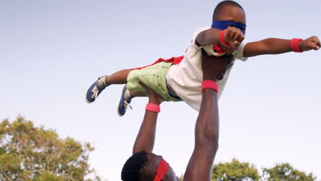 Man-carrying-his-son-in-costume-of-superheroes