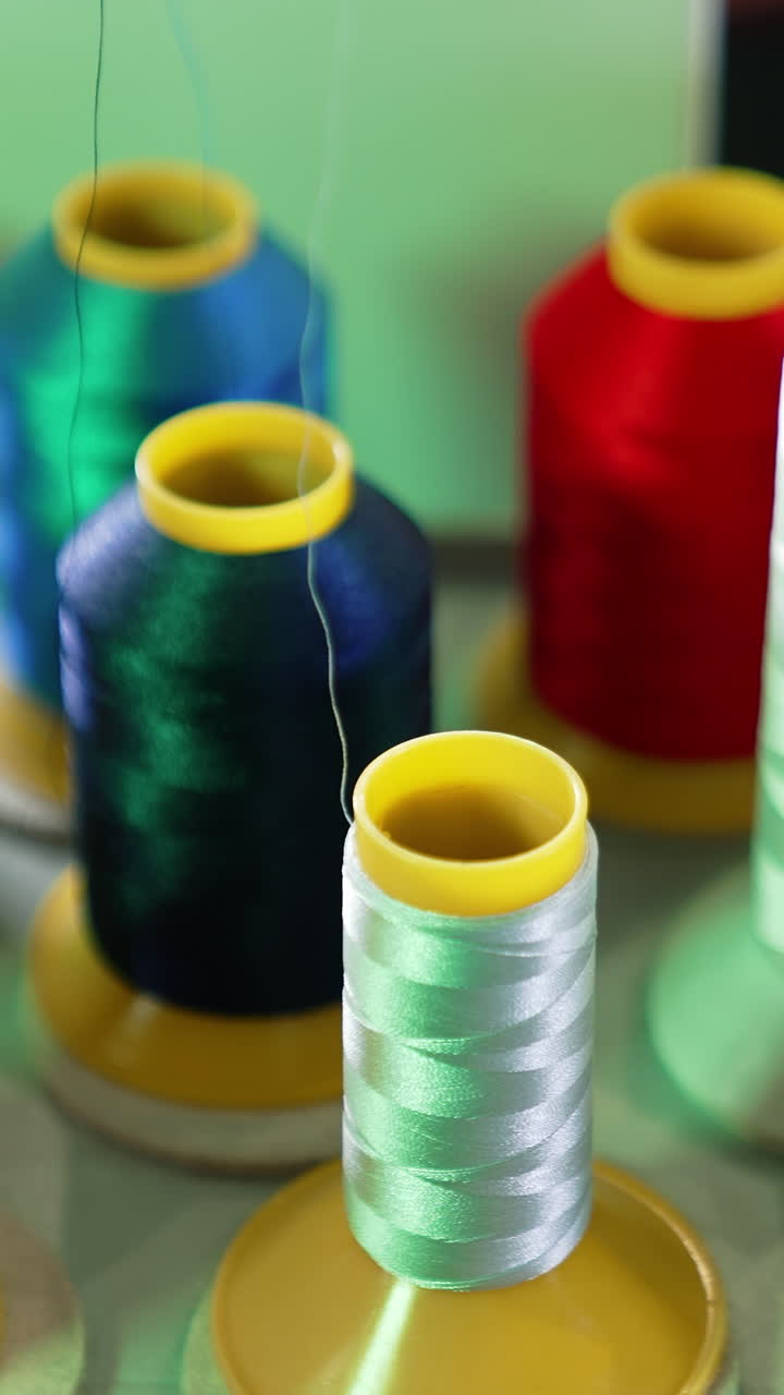 Threads in spools for dressmaker. Collection of colorful threads. Sewing tools. Background of colorful bobbins. Close-up. Hobbies and handicraft concept. Vertical video