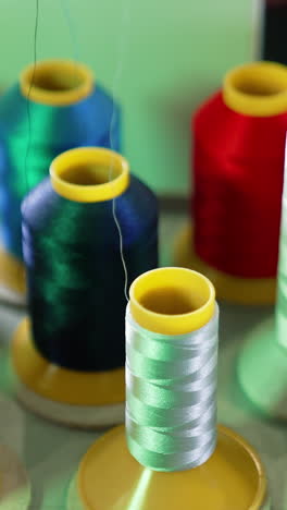 Threads in spools for dressmaker. Collection of colorful threads. Sewing tools. Background of colorful bobbins. Close-up. Hobbies and handicraft concept. Vertical video