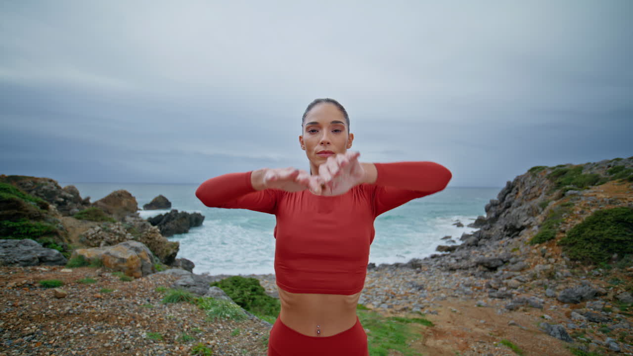 hermosa mujer calentamiento naturaleza estirando los brazos hacia el cielo nublado. atleta delgado