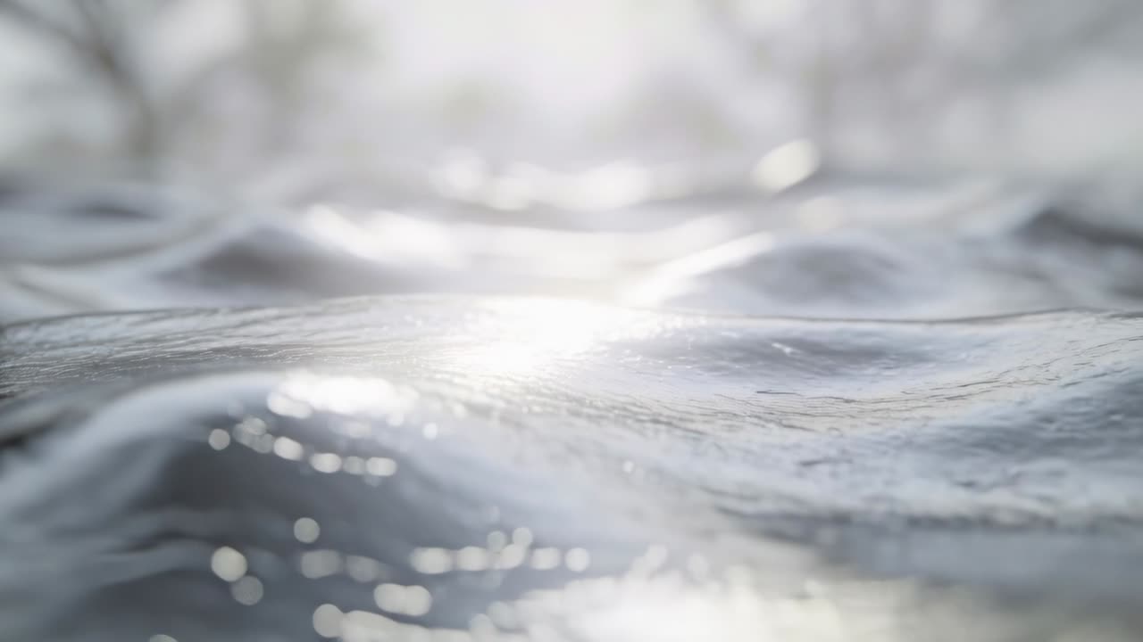 La luce solare cangiante e lo spostamento della telecamera creano sull'acqua lucida striature riflettenti con bagliori e alberi