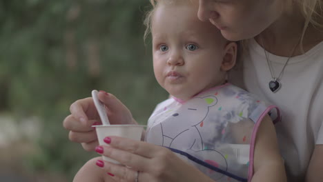 Mutter-Füttert-Ihre-Kleine-Tochter-Draußen