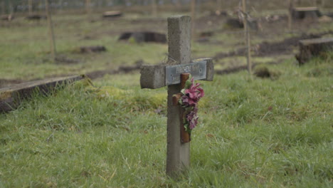 static shot of single gravestone with a ornemental crucifix