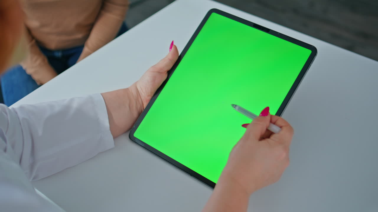 Doctor using a tablet with a green screen