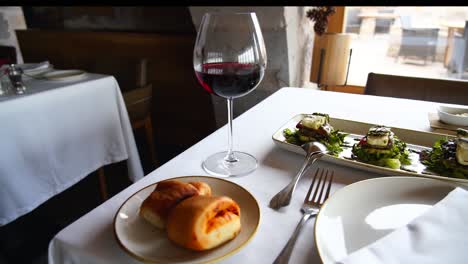 Pfanne-Eines-Schicken-Esstisches-Mit-Einem-Glas-Rotwein,-Zeitlupe-Mit-Traditioneller-Türkischer-Küche-Im-Höhlenhotel