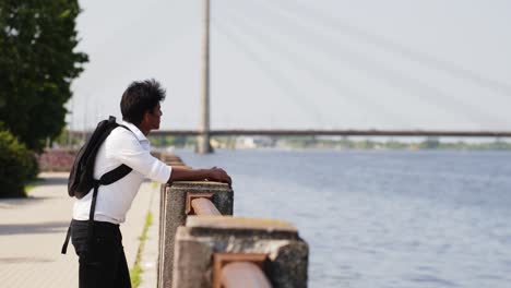 Student-with-white-collar-and-backpack-admires-coastal-city-views