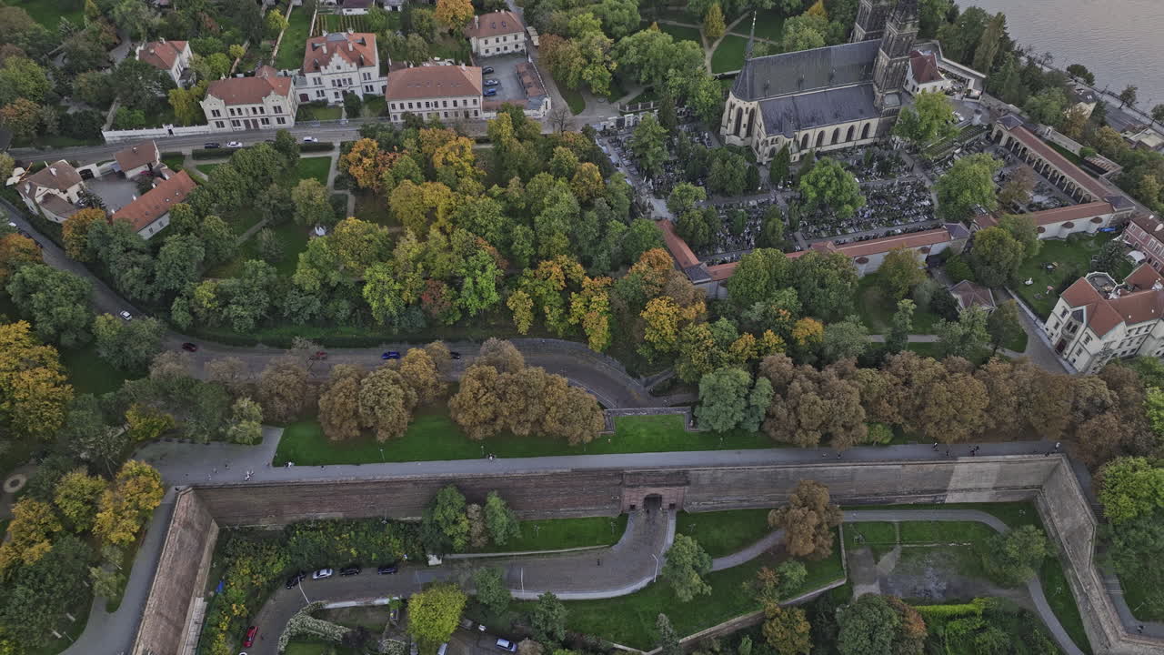 prague czechia aerial v118 vista de pájaros sobrevuelo castillo de vysehrad y puerta de ladrillo en la colina, inclinado hacia arriba capturando el paisaje urbano de smichov a través del río vltava al anochecer - filmado con mavic 3 cine - noviembre 2022