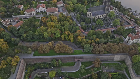 Praga-Chequia-Vista-Aérea-V118-Vista-Aérea-Sobrevuelo-Del-Castillo-De-Vysehrad-Y-Puerta-De-Ladrillo-En-La-Colina,-Inclinado-Hacia-Arriba-Capturando-El-Paisaje-Urbano-De-Smichov-A-Través-Del-Río-Moldava-Al-Atardecer---Filmado-Con-Cine-Mavic-3---Noviembre-De-2022