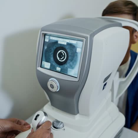 boy is checking eye sight in clinic. apparatus in modern clinic. special technic in ophthalmology cabinet. pediatric concept