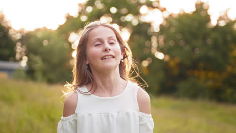 young blonde teen girl walking in summer sunset park looks at camera with alluring look the little