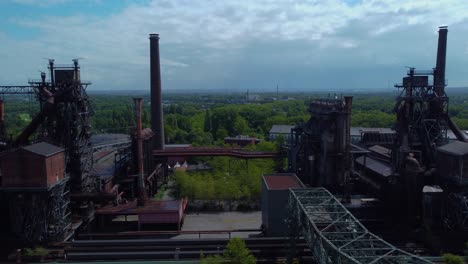 profile view moving overview of well aged factory in the middle of the forest in germany plenty constructions metal houses coverings power plants smokestacks connected together well managed location