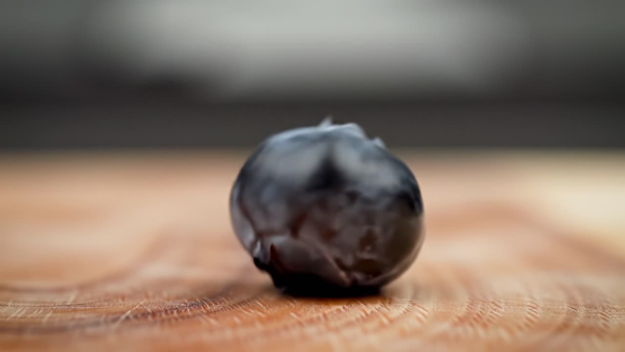 Floating Blueberry Captured in Slow Motion on Wooden Surface for Creative Culinary Inspiration