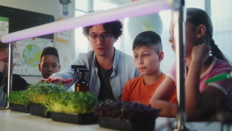 teacher guiding students in a classroom science experiment