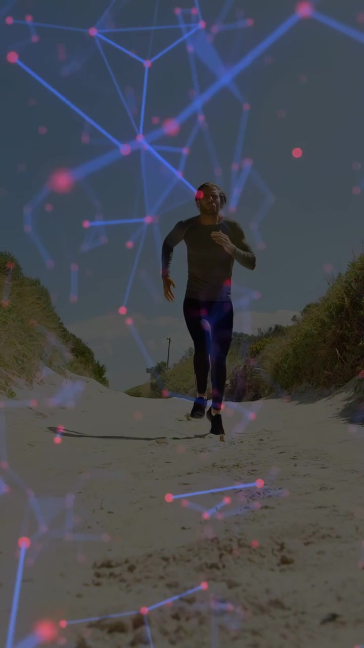 Video verticale: Uomo che corre da una duna, avvicinandosi all'obiettivo per il fitness sulla sabbia, con una rete blu e rosa sull'inquadratura.