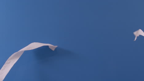 two toilet paper rolls are seen flying across each other in front of a blue screen