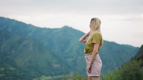 smiling blonde woman amazed of picturesque mountains view