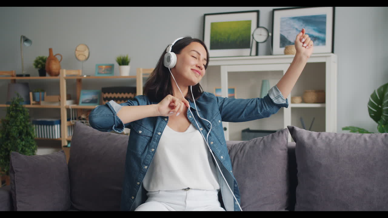 Woman enjoying music on sofa