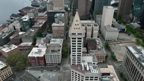 Vista-Aérea-Ascendente-De-La-Icónica-Torre-Smith-En-El-Vecindario-De-La-Plaza-Pionera-De-Seattle