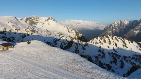 Chamrousse-ski-resort-summit-with-shelter-cabin-at-the-French-Alps,-Aerial-dolly-in-shot