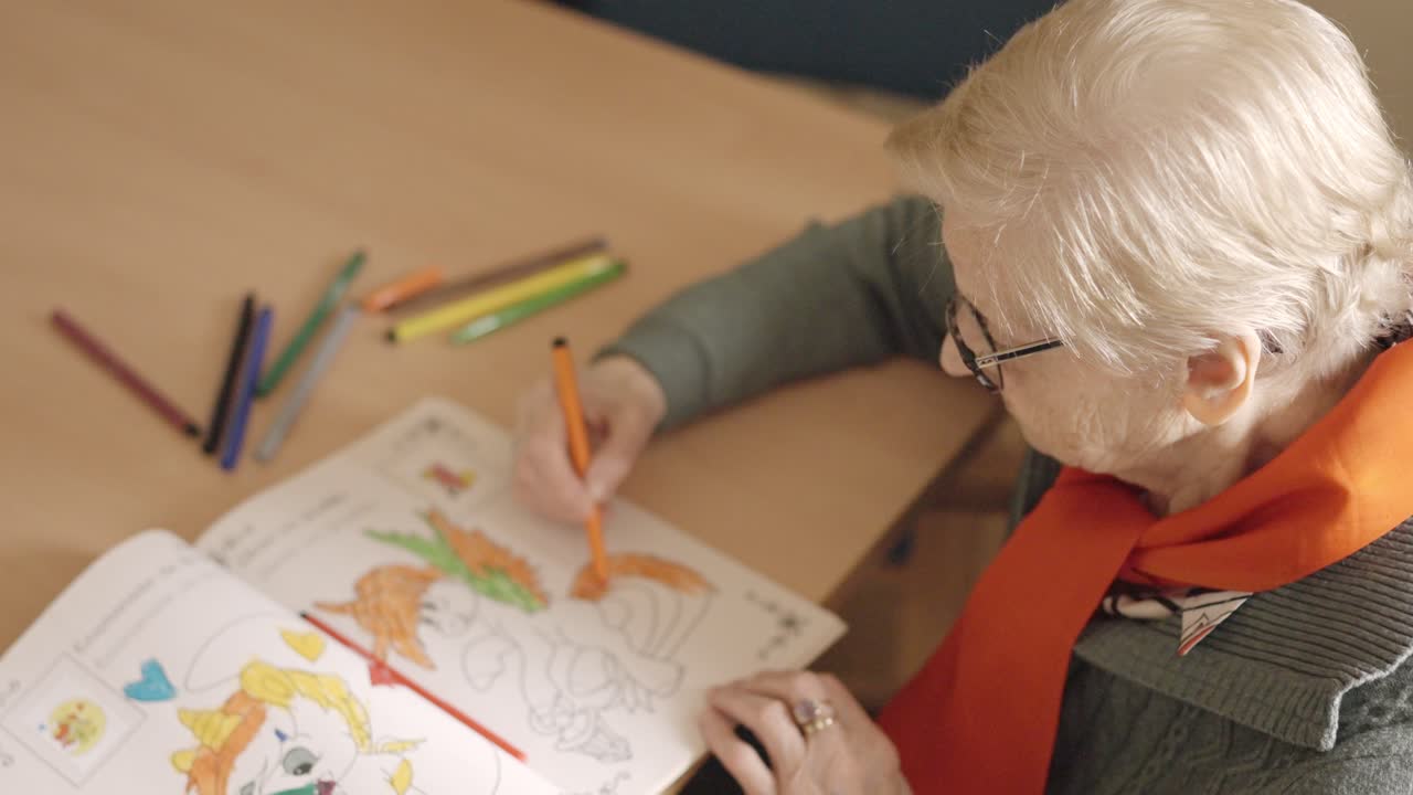 Old woman coloring a draw in a nursing home
