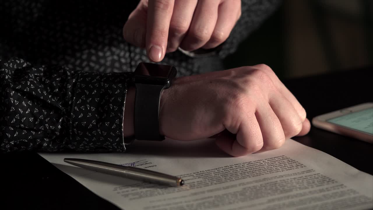 Person Signing a Document with a Smartwatch