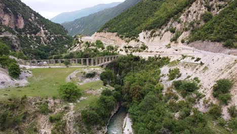 Luftaufnahmen-Des-Historischen-Aquädukts-Von-Ali-Pasha-In-Bënçë,-Albanien,-Zeigen-Sein-Architektonisches-Wunder-Und-Die-Umliegende-Malerische-Landschaft