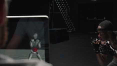 hombre en forma usando traje de captura de movimiento juego de computadora realizando artes marciales boxeo usando traje de mo-cap para animación de personajes 3d para lucha de realidad virtual