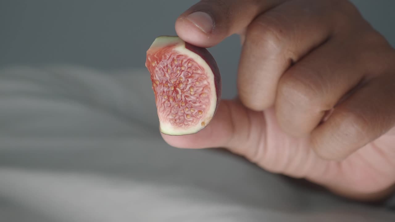 Close-up of a fig slice held in hand
