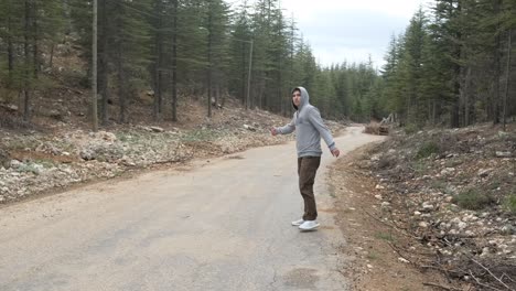 Hitchhiking-on-asphalt-road-in-forest