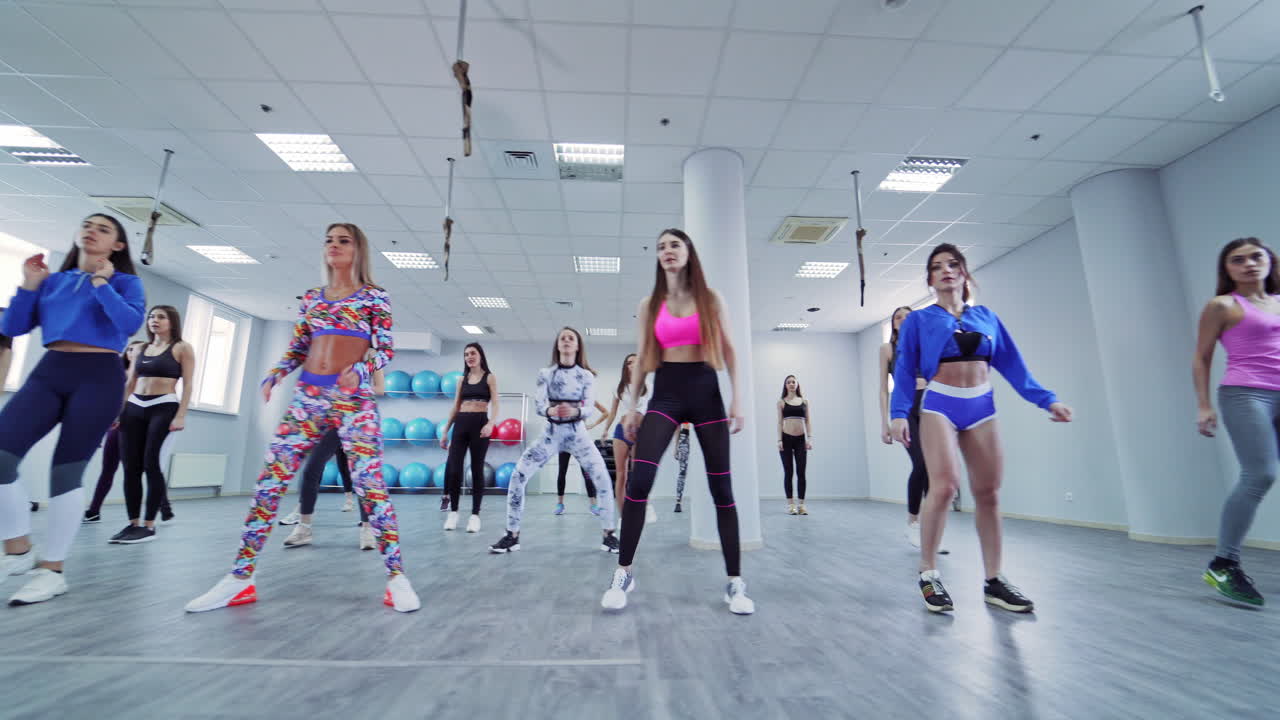 Gruppo di donne che si allenano in palestra. Ragazze che fanno esercizi di fitness indoor di cross training.