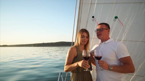 couple enjoying wine on a sailing trip at sunset