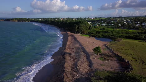 vista aérea de una playa de arena cerca de un pequeño pueblo