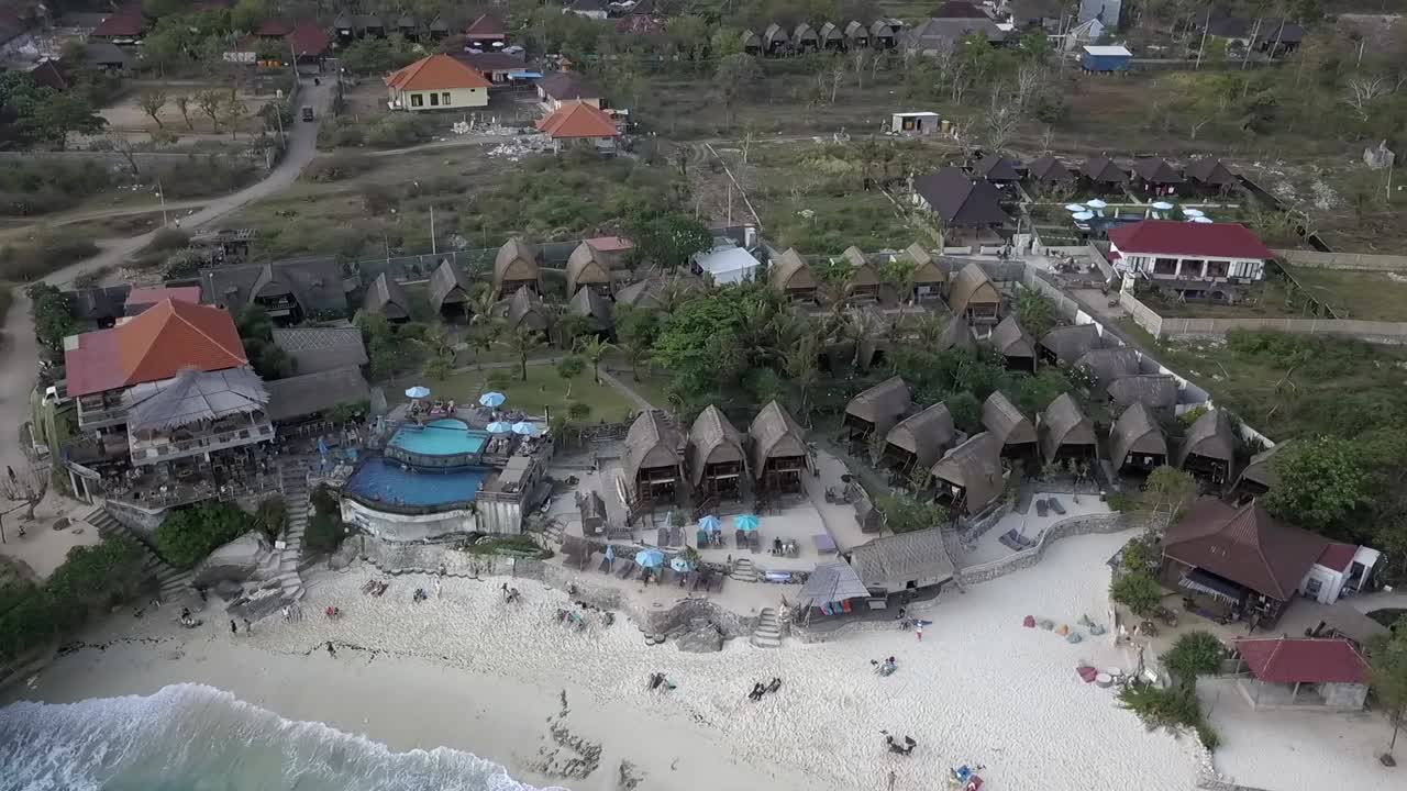 Spettacolare ripresa aerea dall'alto con drone di un'idilliaca spiaggia da sogno con resort fronte mare a Nusa Lembongan a mezzogiorno, Bali 2017.