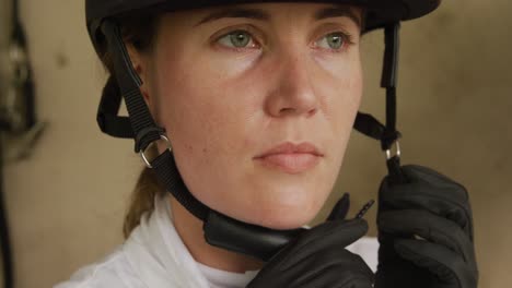 caucasian woman putting on her helmet