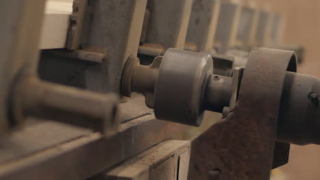 Industrial machine tightens bolts in a workshop, close up in slow motion