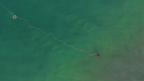 aerial top down view of fisherman setting the trap for catching fish over the surface of water in ocean