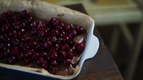 cherry cake. chef adding cherry to chocolate cake with spoon. sweet ingredient