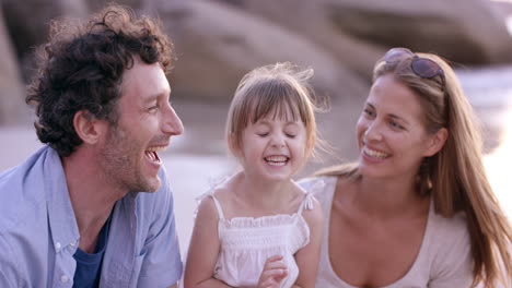 happy family playing on the beach mother father and daughter looking at view  at sunset on vacation