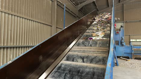 Conveyor-moves-paper,-cardboard-waste-to-separator-in-paper-recycling-plant