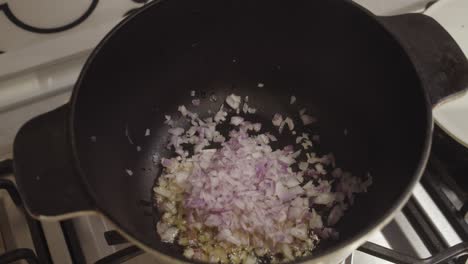 Adding-diced-onion-into-the-hot-cooking-pot
