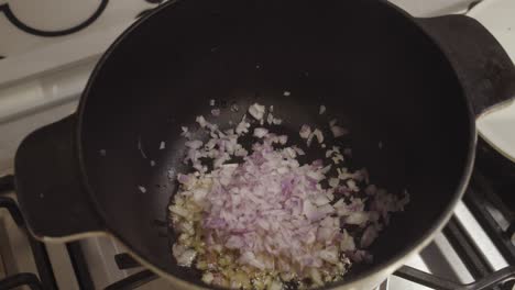 agregando cebolla picada en la olla caliente