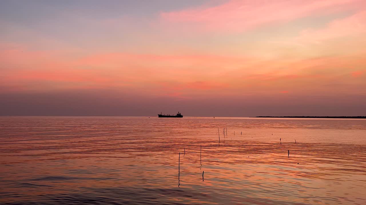 멀리 있는 배와 함께 평온한 해가 지는 풍경